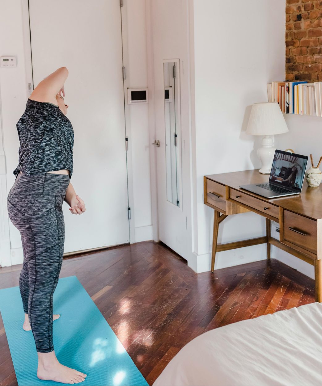 woman stretching in home office to avoid effects of prlonged sitting