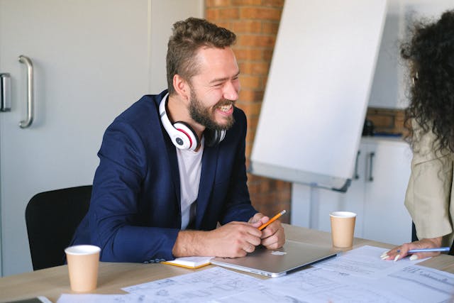 man smiling at desk looking happy at work